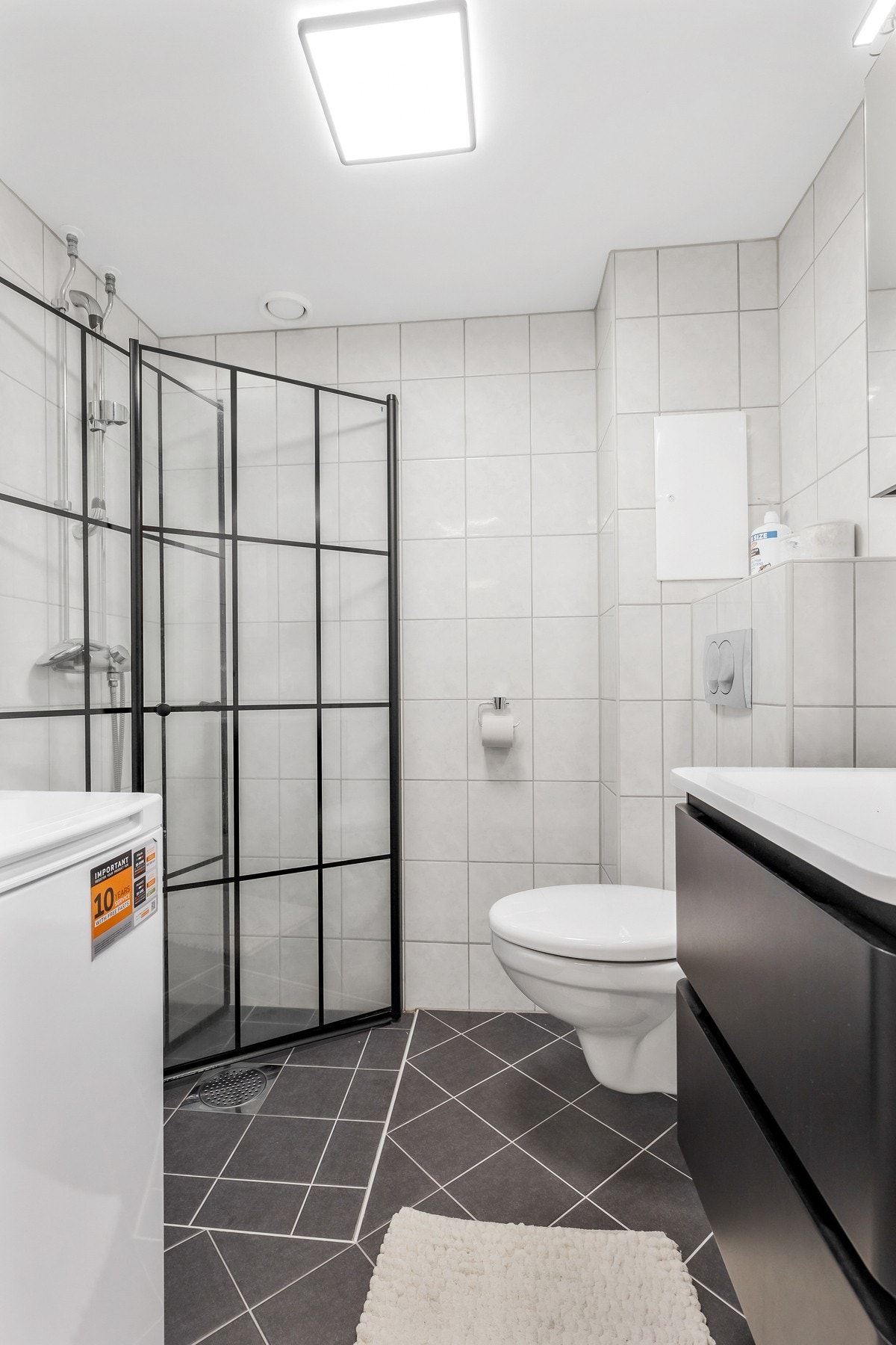 Rommet er utstyrt med dusjhjørne med innfellbare vegger. vegghengt toalett og opplegg for vaskemaskin Galleribilde