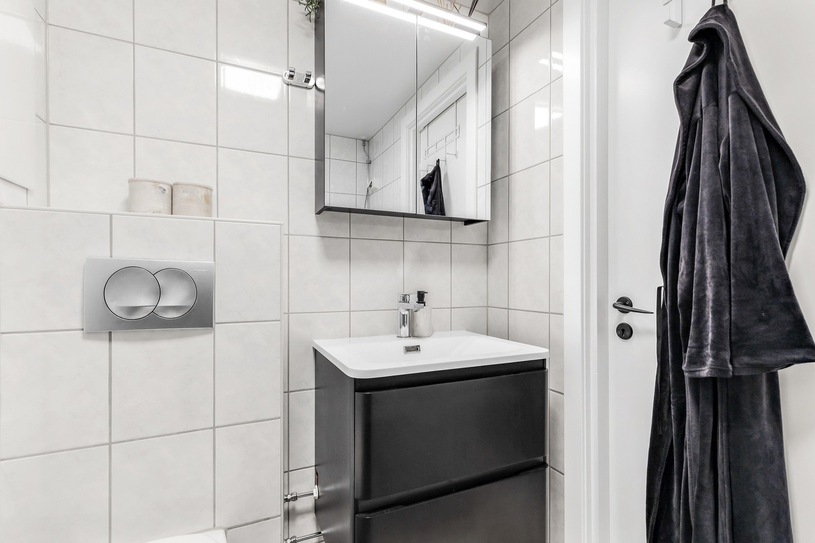 Videre er det en vegghengt servantinnredning med skuffer og ovenpåliggende servant med ett-greps armatur Galleribilde