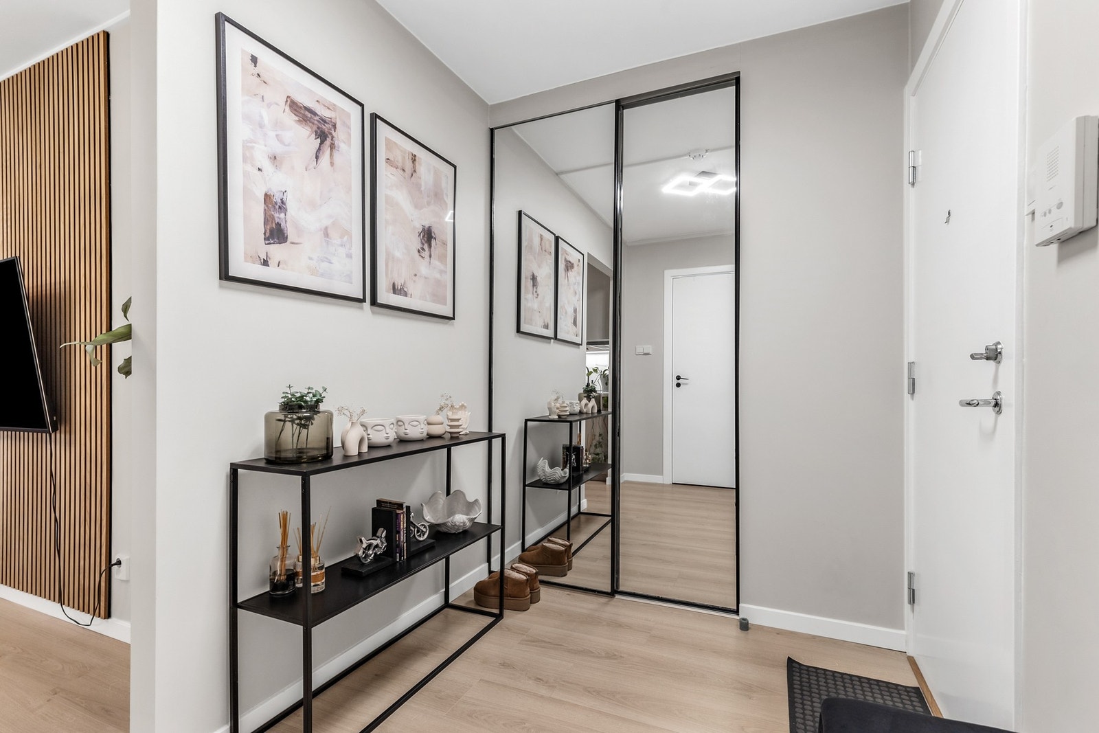 Pen entré med laminat på gulv og skyvedørsgarderobe med speilfronter Galleribilde