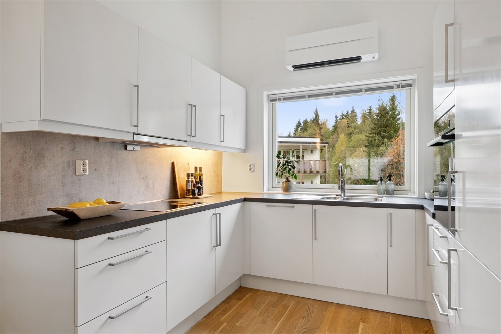 Kjøkkenet har en moderne innredning med glatte fronter og godt med benkeplass. Galleribilde