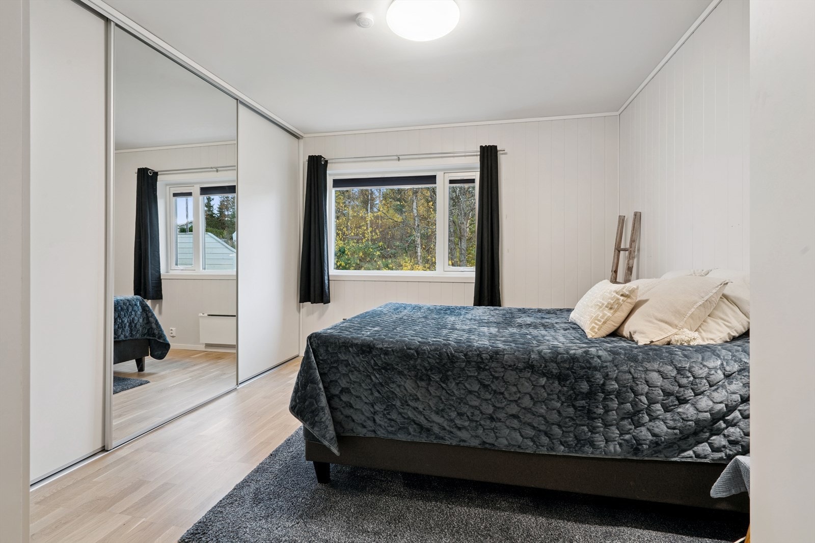 En stor skyvedørsgarderobe med speilfronter gir rikelig med oppbevaringsplass. Galleribilde