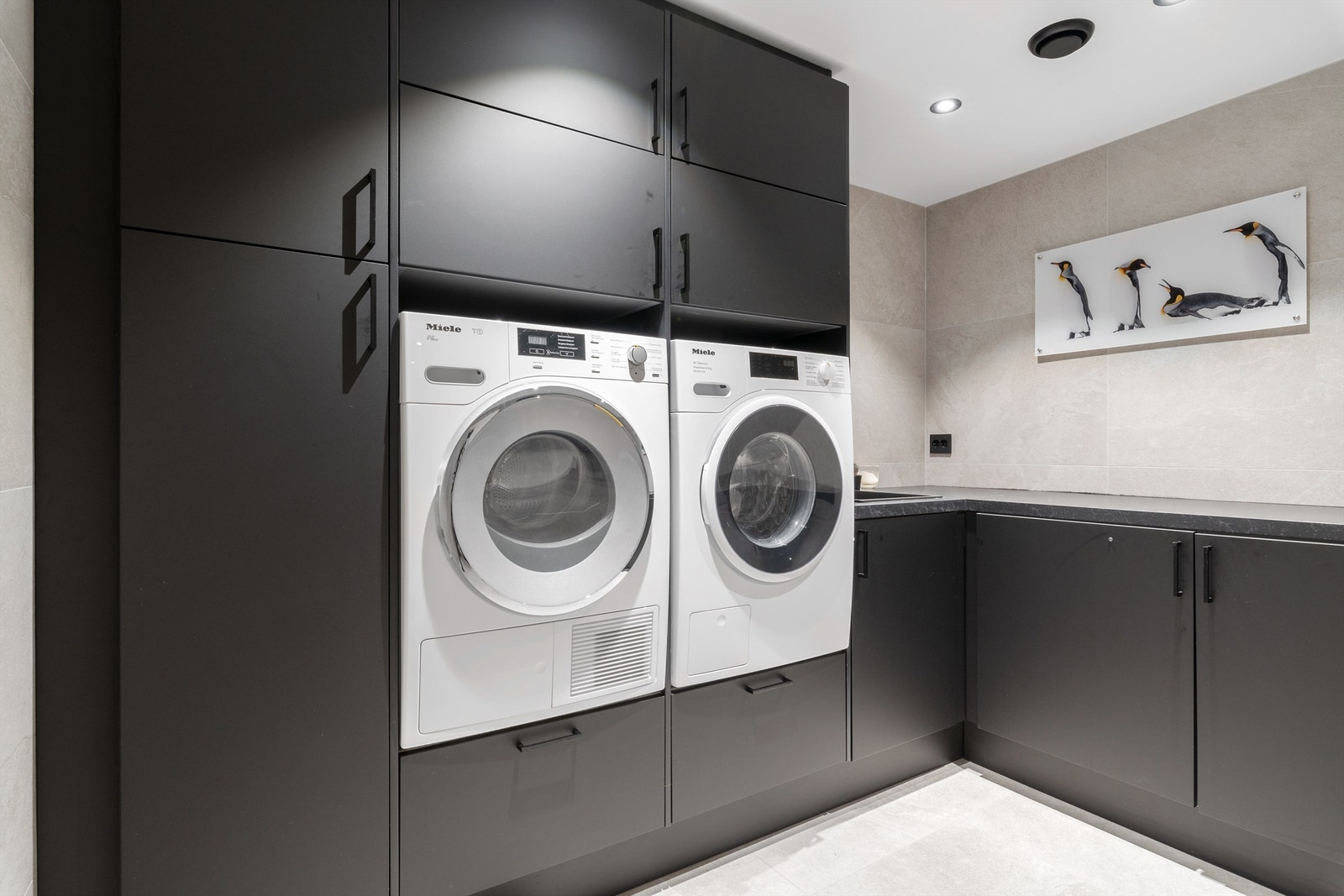Vaskeromsløsningen er svært praktisk, "skjult" bak badet. Innredningen gir både oppbevaringsplass og arbeidsflater og har nisje for to maskiner, i ergonomisk arbeidshøyde Galleribilde