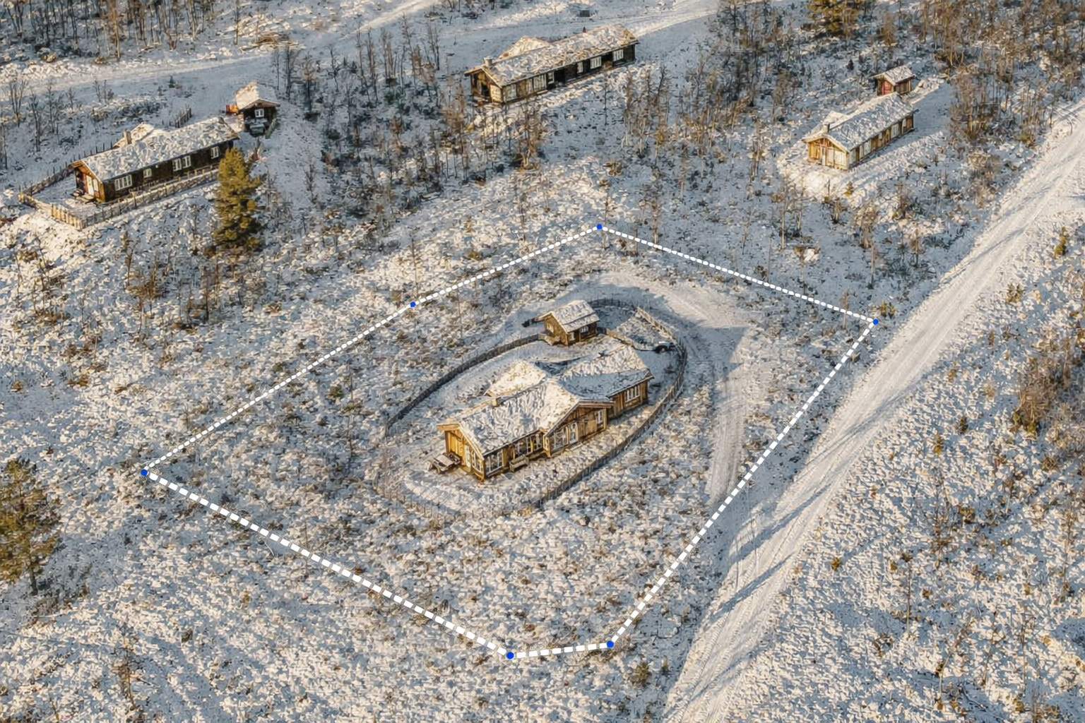 Bildet viser tilnærmet tomtegrense. Til tross for at skigarden ligger tett inntil hytteveggen, fremstår tomten som romslig og gir gode muligheter for uteopphold, lek og fremtidig bruk. Galleribilde