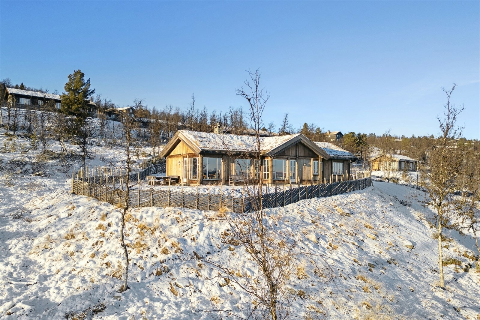 Hytta er oppført i 2021 med moderne standard og byr på 3 soverom, 2 bad, badstue og eget vaskerom, samt en romslig og åpen stue-/kjøkkenløsning med nydelig utsikt mot fjellheimen Galleribilde