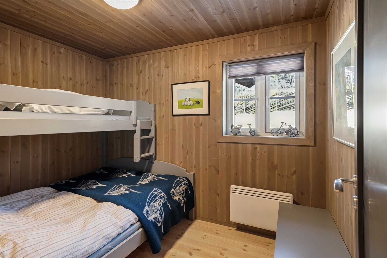 Hyttas andre soverom har god størrelse og er utstyrt med plassbygde senger, som gir både praktisk utnyttelse av plassen og god komfort. Galleribilde