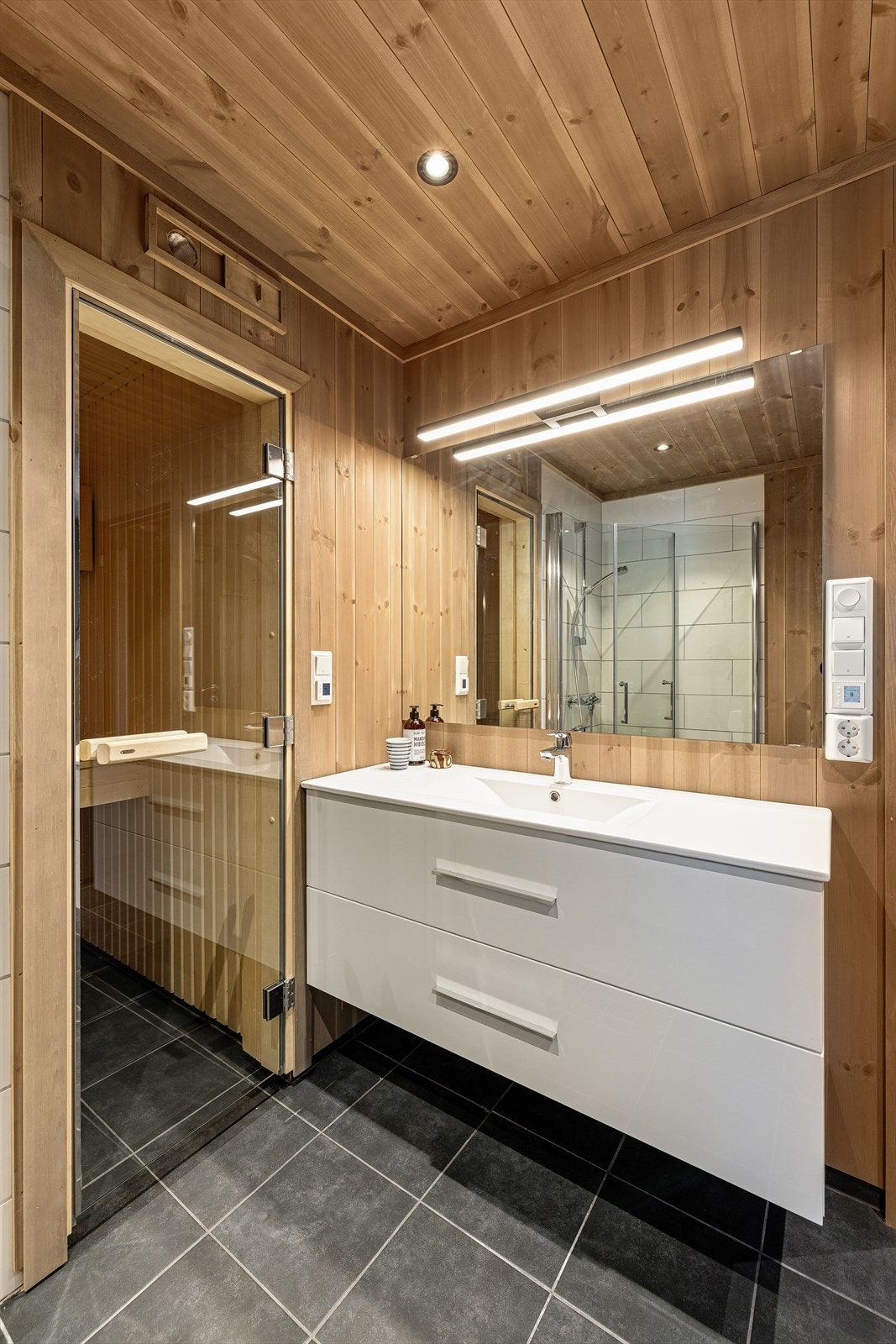 Badet har flislagt gulv og panel på vegger og i tak, som gir et lyst og innbydende preg! Galleribilde