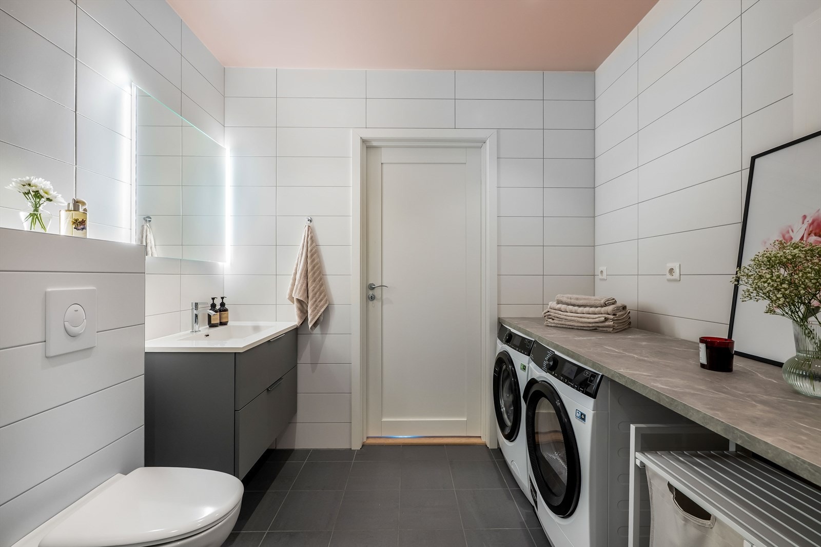 Badet er ellers utstyrt med dusjhjørne, vegghengt toalett og baderomsinnredning med nedfelt servant. Badet har også opplegg for vaskemaskin og plass til tørketrommel med benkeplass over som gir gode arbeidsflater. Galleribilde