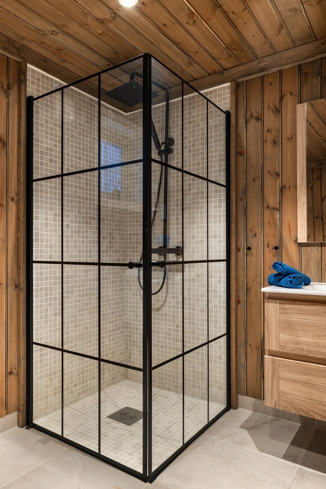 Dusjhjørne med flotte innfellbare glassdører og sort armatur med både hånd- og regnfallsdusj. Galleribilde