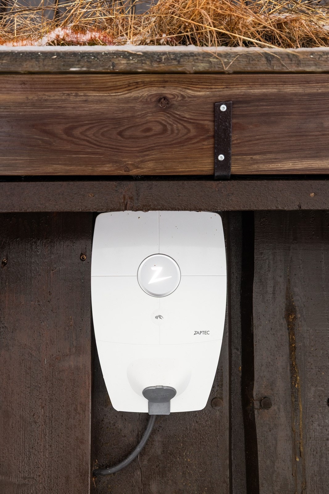 Det er montert elbil-lader på hytteveggen. Galleribilde