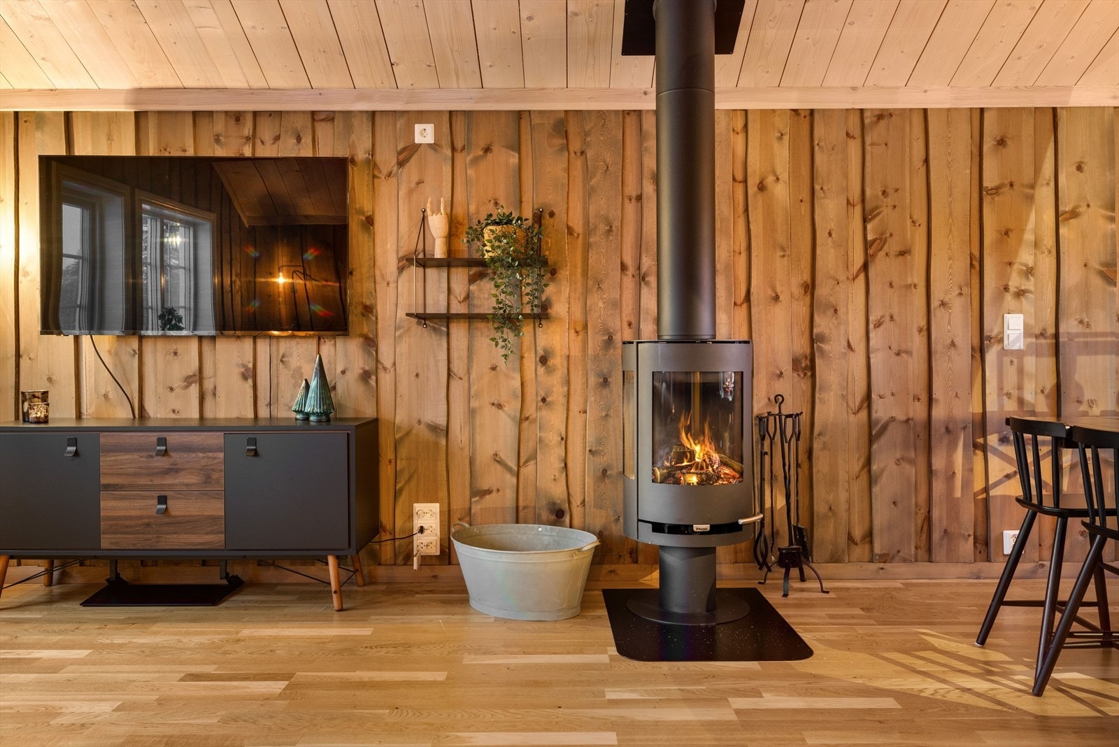 Som et fint midtpunkt i rommet er det en moderne vedovn som både gir god varme og bidrar til ekstra hygge. Galleribilde