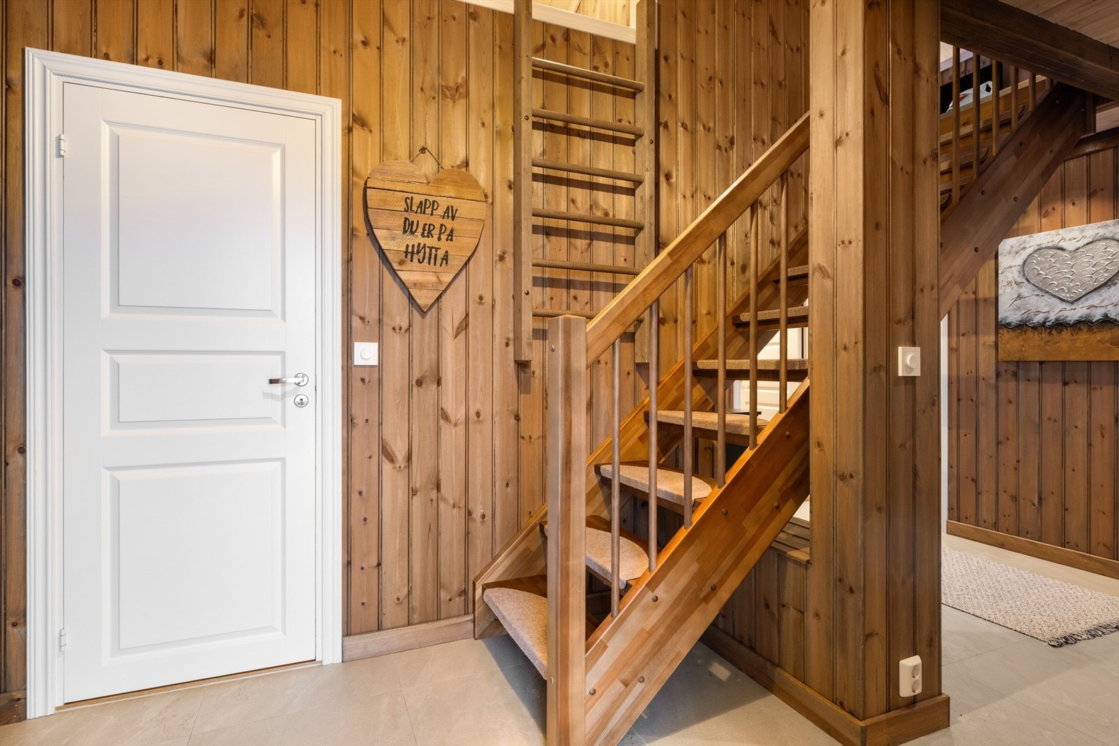 Entréen har god standard fra 2020 med grå fliser på gulv, lun trepanel på veggene og skjult elektrisk anlegg. Galleribilde