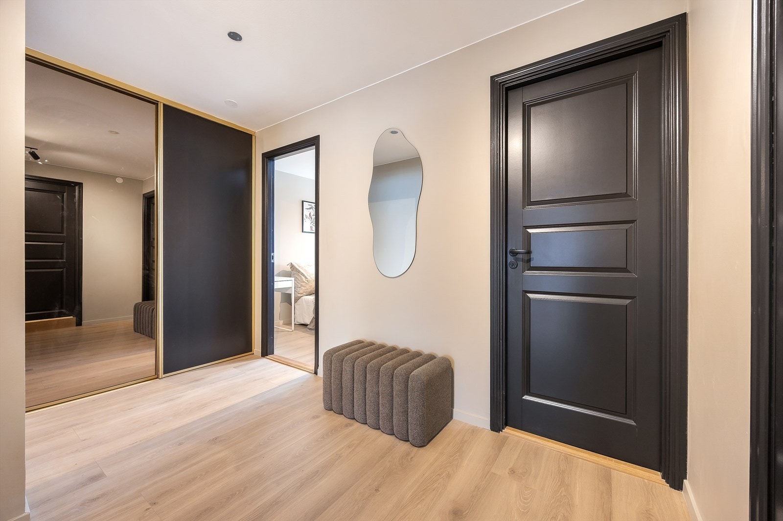 Entreen har en stilfull og praktisk skyvedørsgarderobe Galleribilde