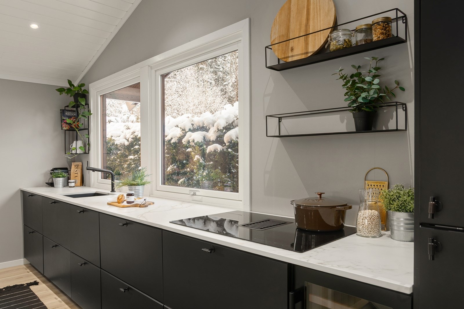 Kjøkkenet er utstyrt med integrerte hvitevarer som mikro, stekeovn, platetopp, kjøleskap og oppvaskmaskin, samt nisje for vinskap Galleribilde