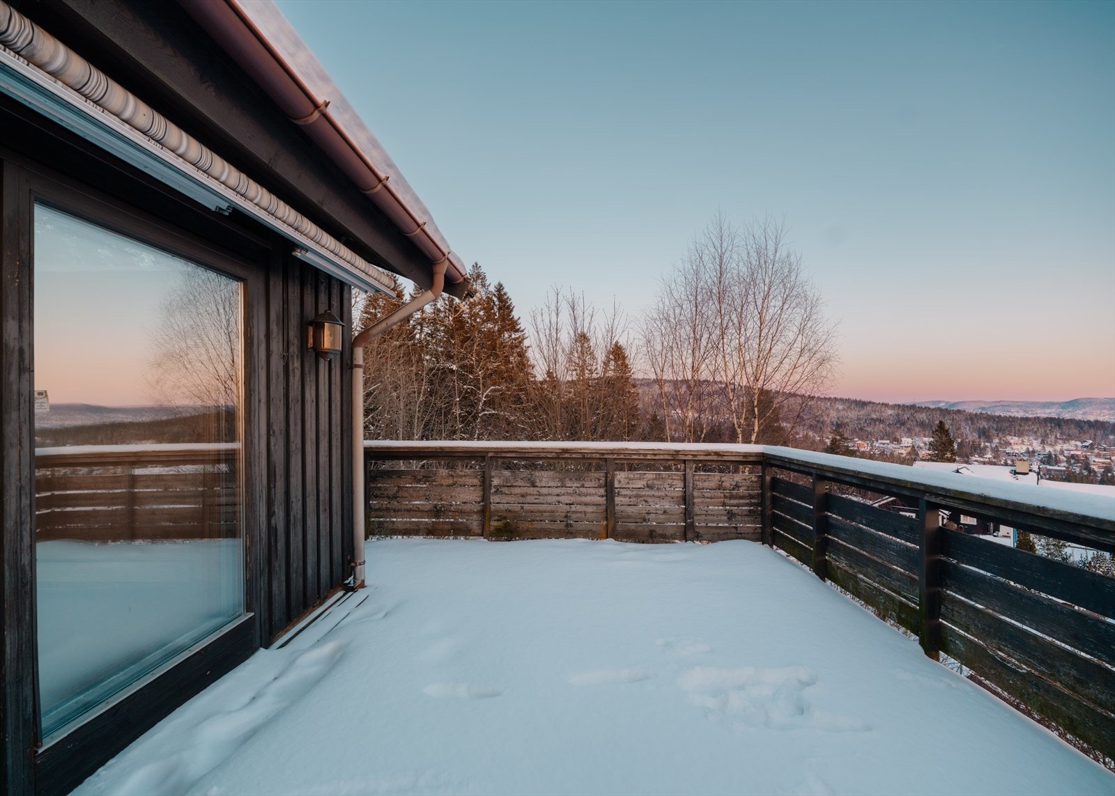 Fra terrassen er det trapp ned til hagen på boligens fremside Galleribilde