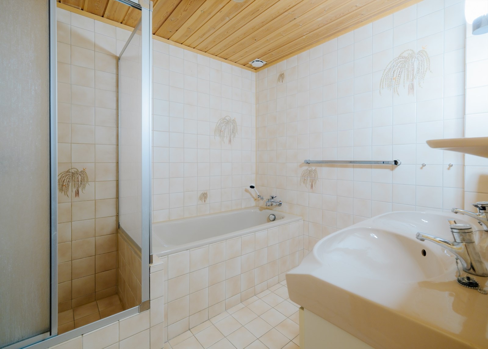 Helfliset bad i 1. etasje fra byggeår. Innredet med badekar, dusj og baderomsinnredning med to servanter Galleribilde