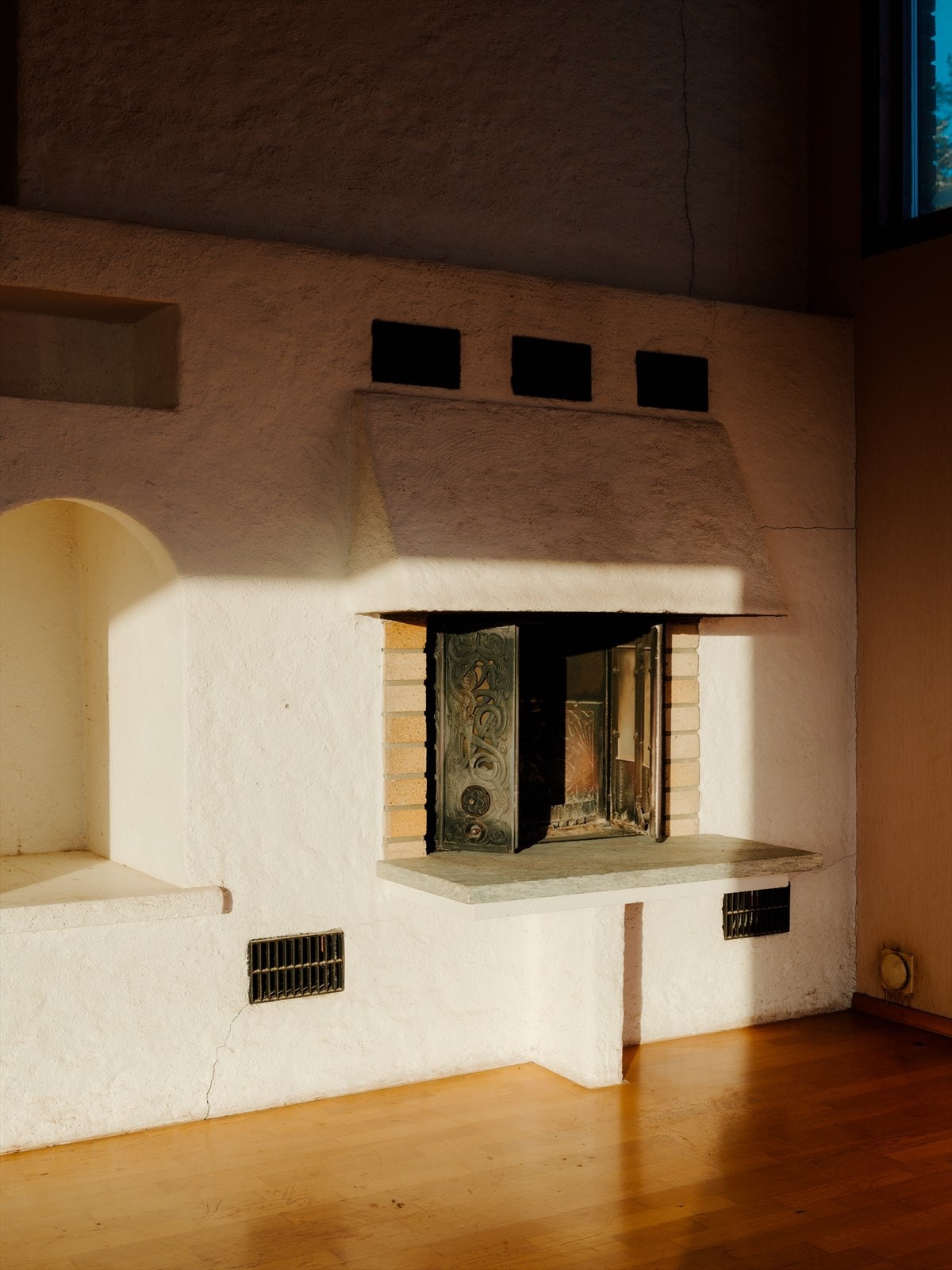 Åpen peis plassert i hjørnet av stuen Galleribilde