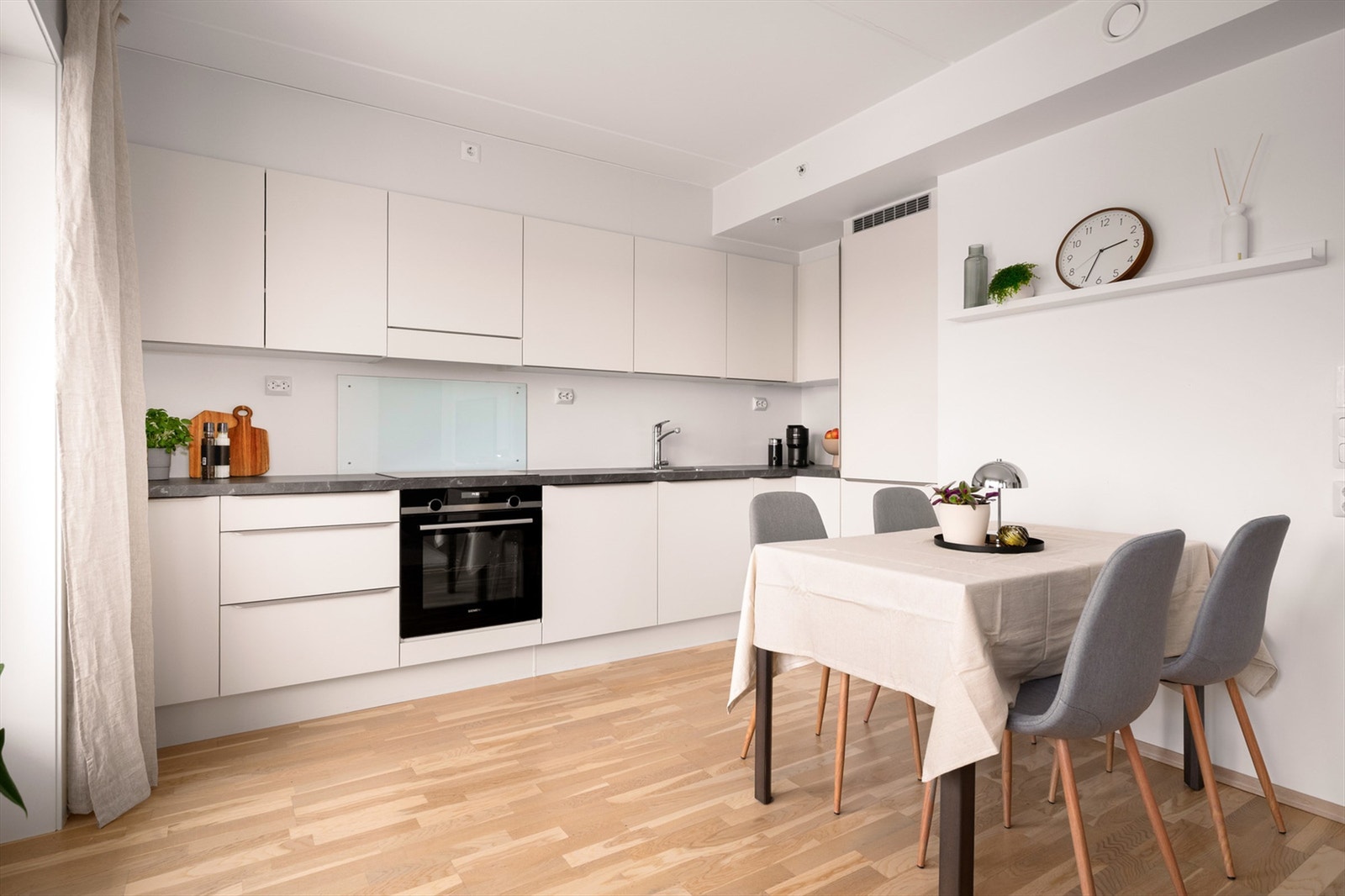 Kjøkkeninnredningen er tidløs og stilren med glatte fronter og laminat benkeplater med nedfelt oppvaskkum og et greps armatur. Galleribilde