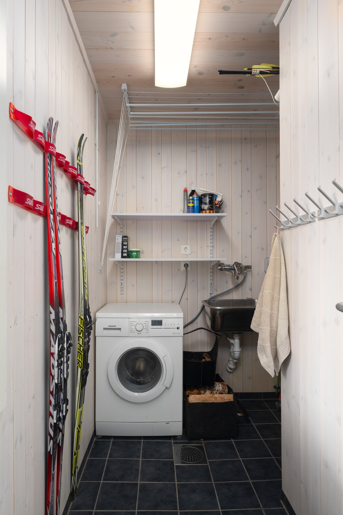 Vaskerom/teknisk rom med flislagt gulv med varme. Utslagsvask, opplegg til vaskemaskin, bereder, rør i rør skap og sikringsskap. Galleribilde