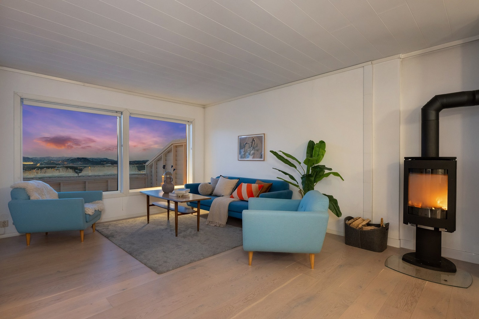 Pen stue med lyse gulv, flott peis og store vinduer. Galleribilde