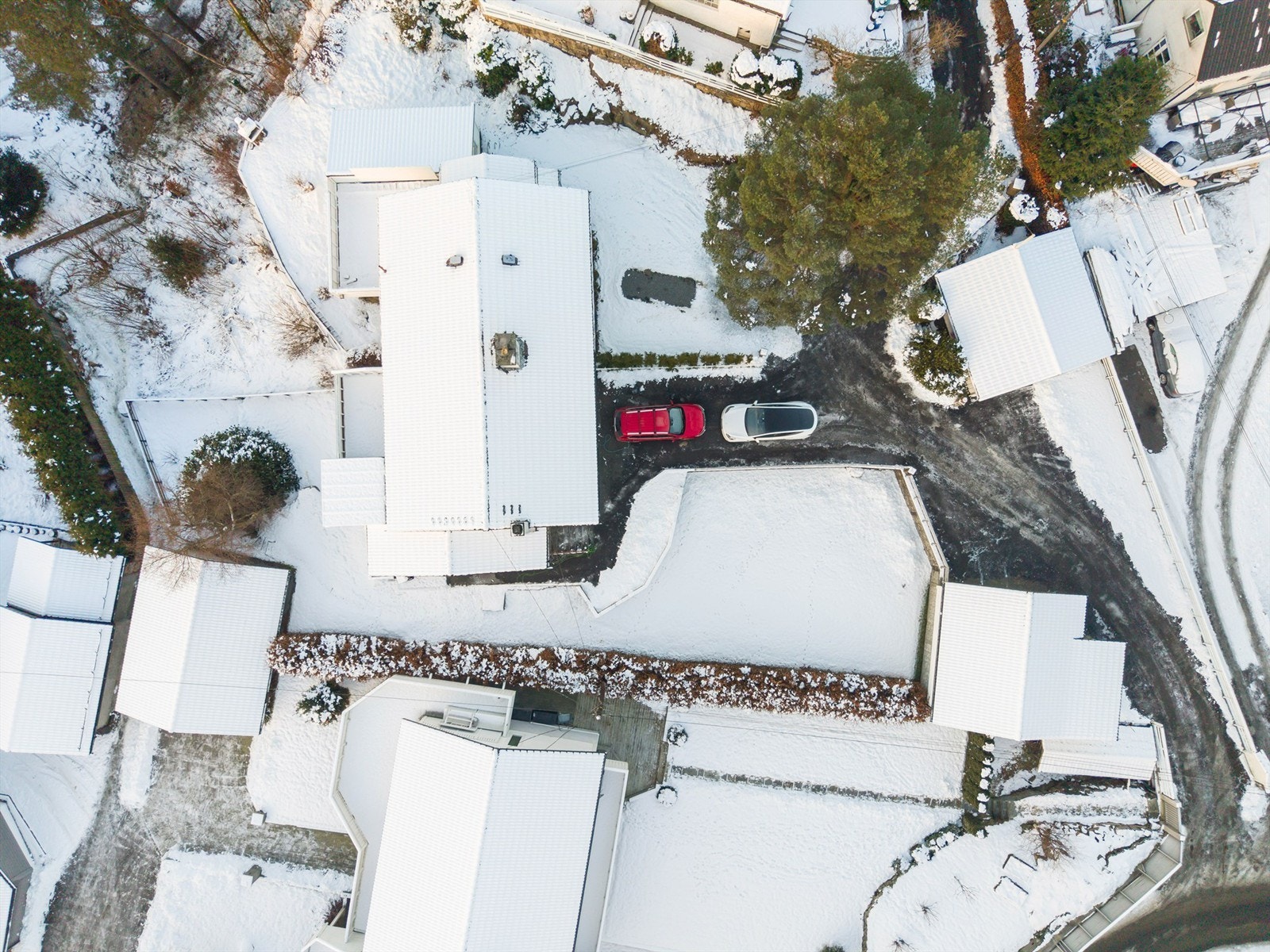 Eiendommen sett fra luften. God hage fra dobbelgarasjen til huset og på nedsiden. Galleribilde