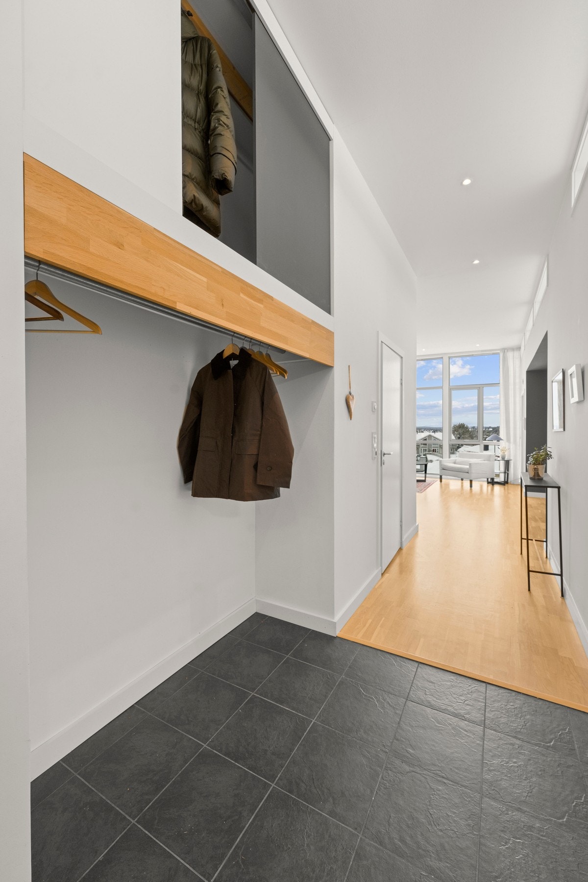 Langs med den ene veggen er det en praktisk garderobeløsning med plass til å henge av seg yttertøy. Galleribilde