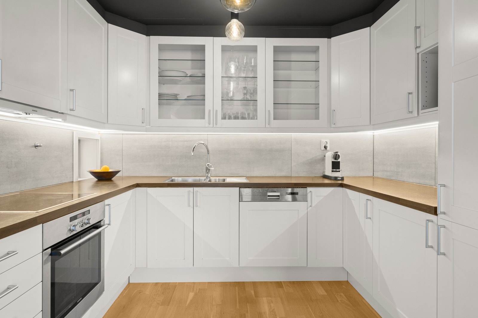 Kjøkkeninnredningen har lyse fronter kombinert med enkelte glassfelte overskap. Videre er det laminerte benkeplater med nedfelt oppvaskkum. Galleribilde