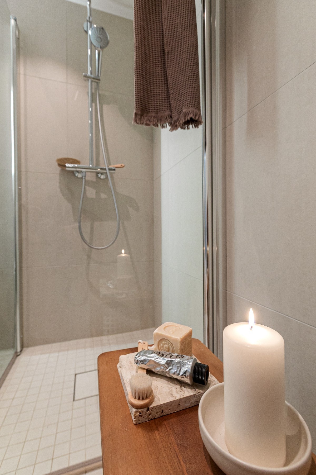 Badet har en deilig nedsenket dusjsone, skjermet med vendbare dører i herdet glass, samt både regnfalls- og hånddusj. Galleribilde