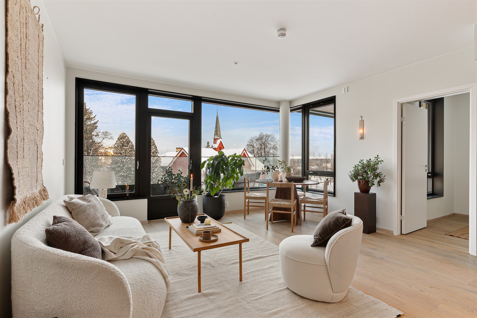 Store vindusflater og generøs takhøyde slipper inn rikelig med naturlig lys, samtidig som leilighetens plassering i 4. etasje gir skjermet utsikt og begrenset innsyn. Galleribilde