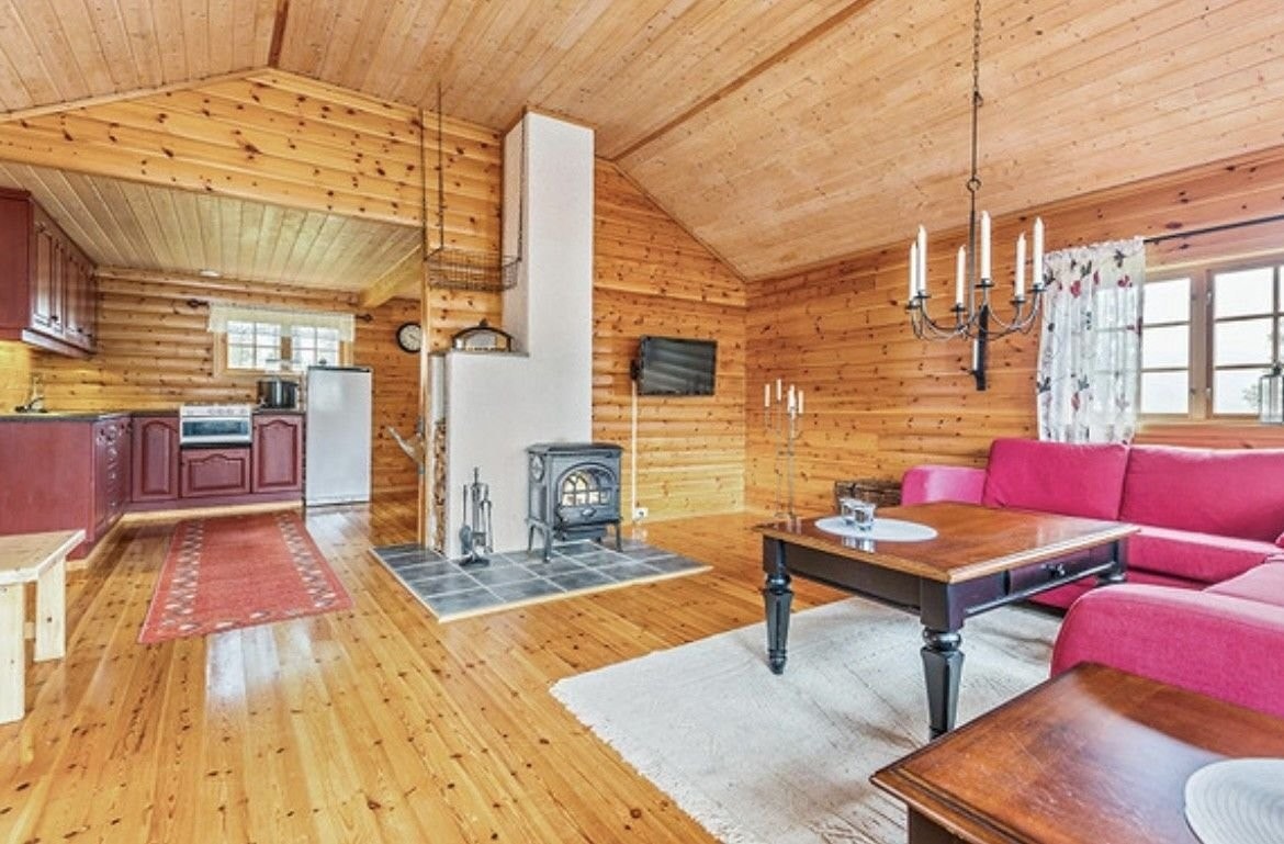 Stue med åpen løsning mot kjøkken. I stue er det montert vedovn for oppvarming. Galleribilde