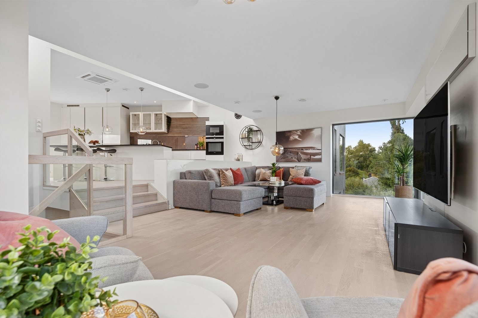 Kjøkken med spisestue er adskilt med tre trappetrinn opp fra stuen. Trappeløp i tre og glass. Varierende takhøyder og store takvinduer gir boligen arkitektonisk preg og mye naturlig innlys. Galleribilde