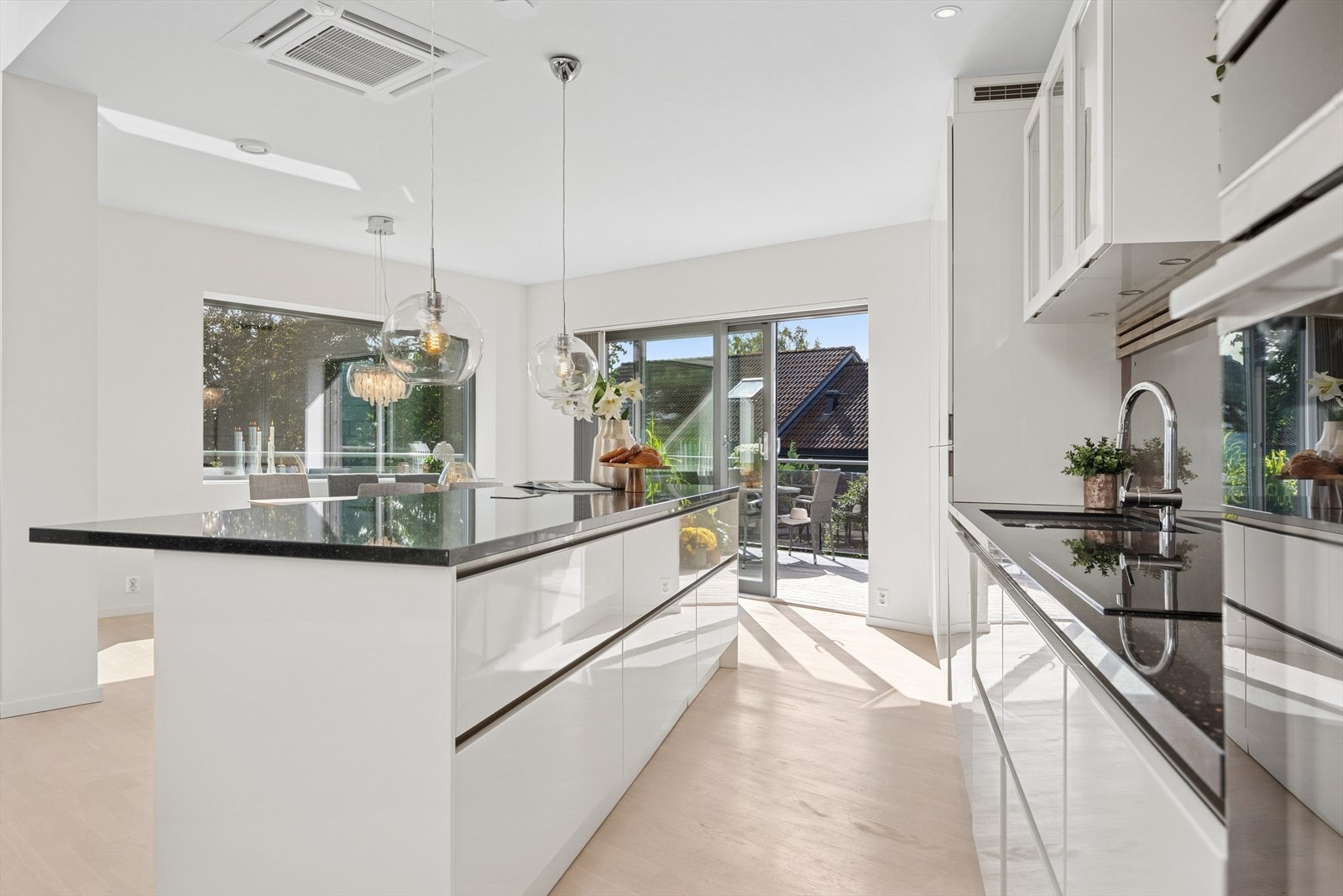 En stor kjøkkenøy i lik utførelse gir en stor arbeidsbenk, rikelig med skuffeplass og sitteplasser i front. Galleribilde