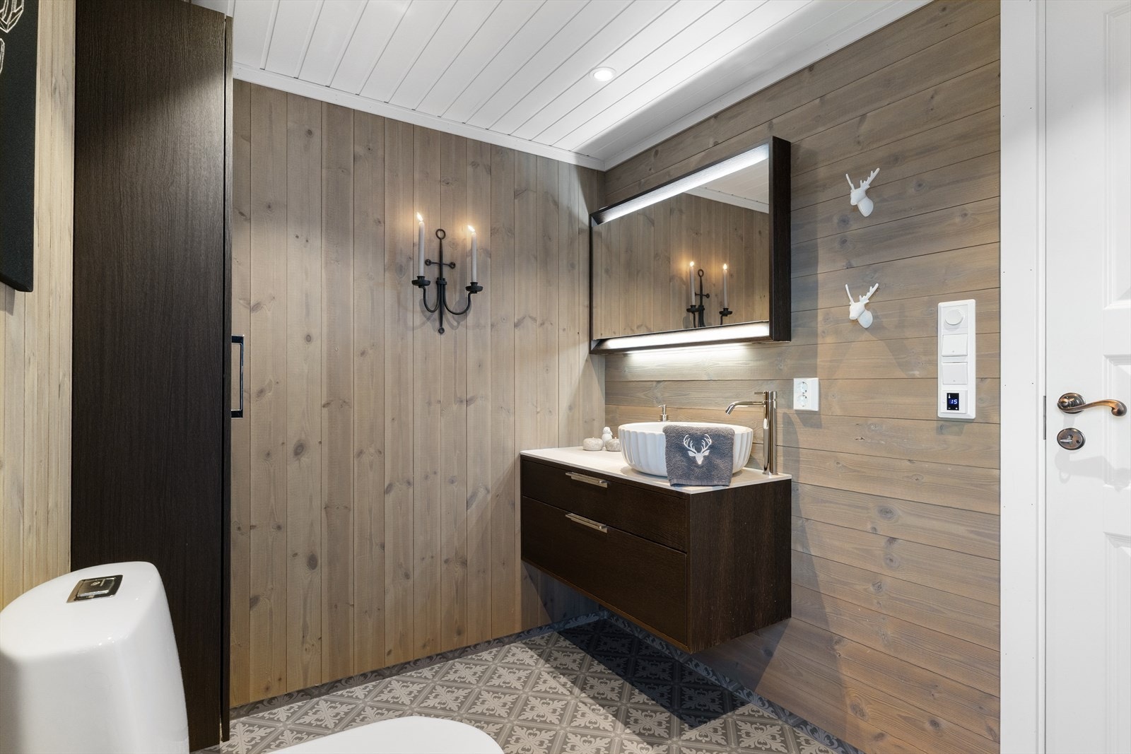 Rommet er utstyrt med servant på innredning, toalett og dusjhjørne med dusjvegger. Galleribilde