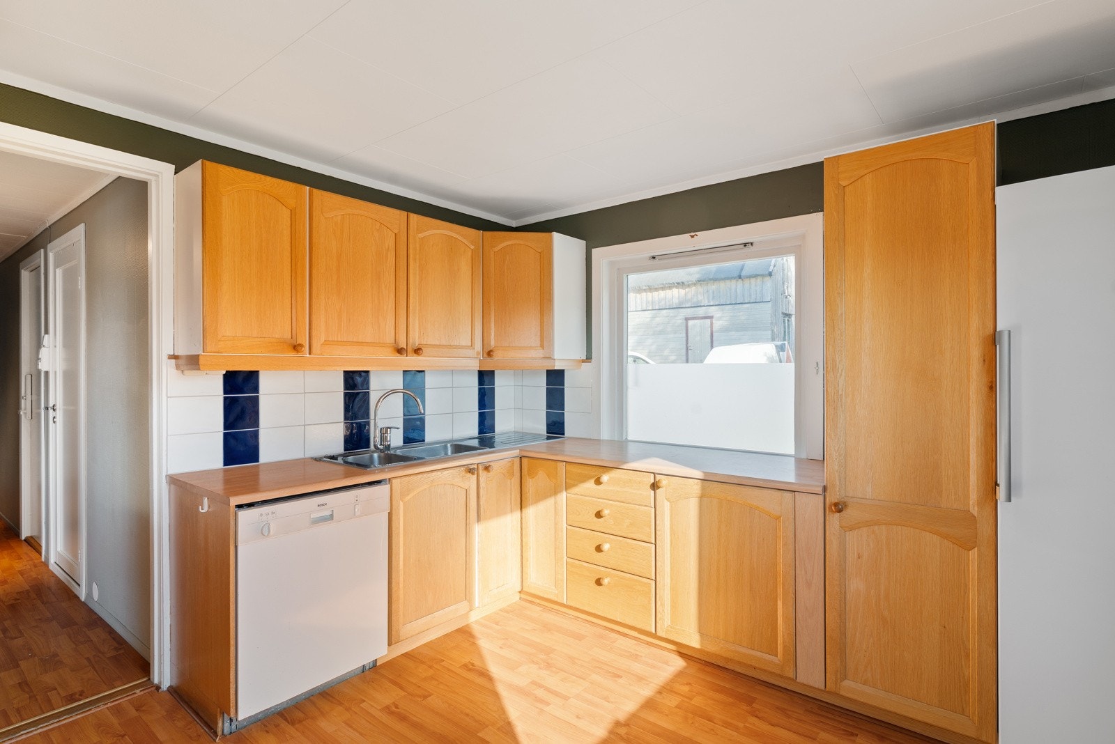 Kjøkkenet er innredet med komfyr, servant, oppvaskmaskin og kjøleskap. Galleribilde