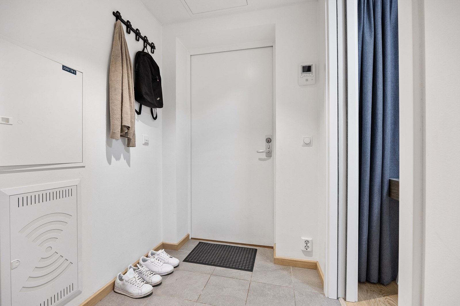 Entréen er lys og luftig med flislagt gulv og hvitmalte vegger. Galleribilde