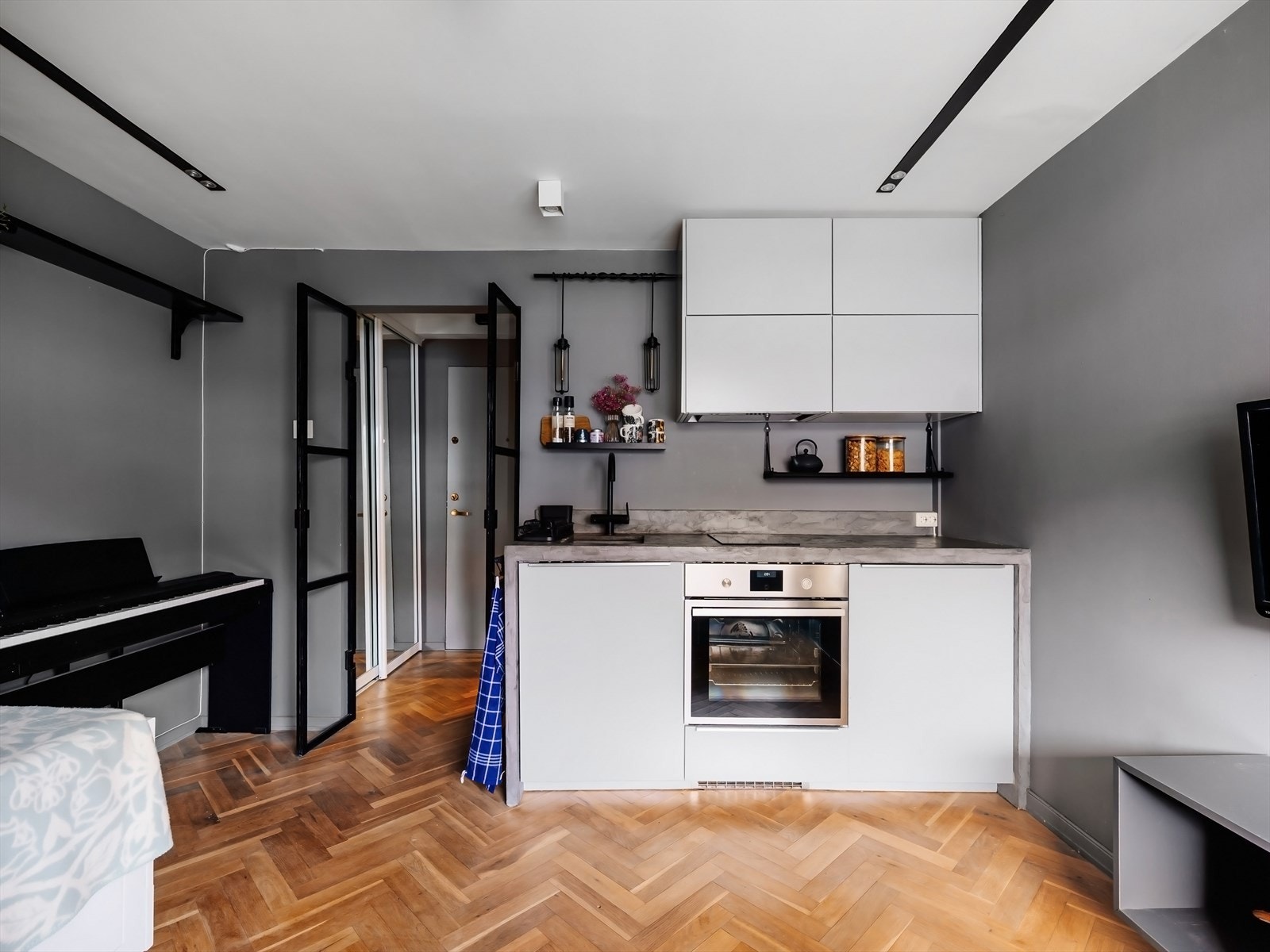 IKEA-kjøkken med slette fronter, sømløs benkeplate i mikrosement med forlengelse langs sidene og med underlimt kum i komposittmateriale. Galleribilde