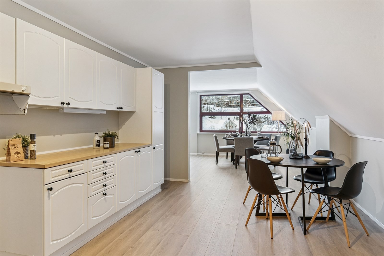 Kjøkkenet er praktisk utformet med god skap- og benkeplass. Innredningen har malte, profilerte fronter og en benkeplate i laminat. Avstemte farger på vegger og lekre gulv - byttet i 2025 Galleribilde