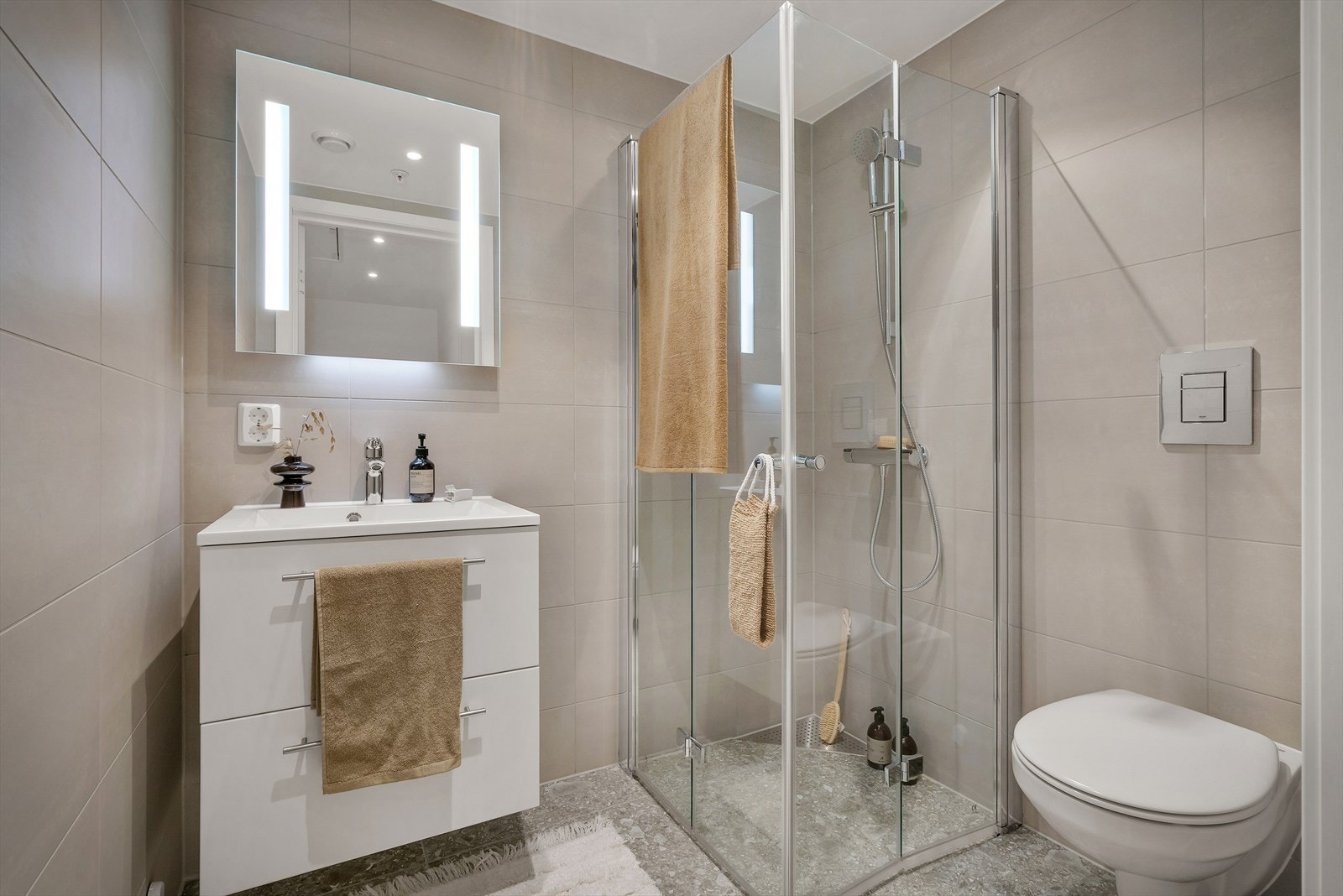 Etasjens bad står i stil med resten av boligen og er innredet med nedfelt servant, veggmontert toalett og dusjvegger/hjørne. Galleribilde