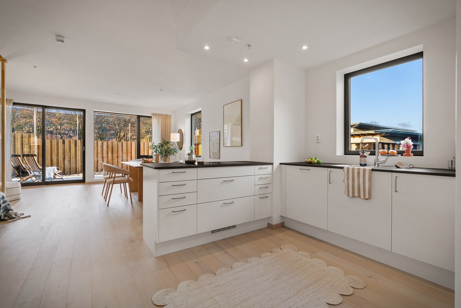 Kjøkkenet inneholder lyse glatte fronter og laminat benkeplate. Galleribilde