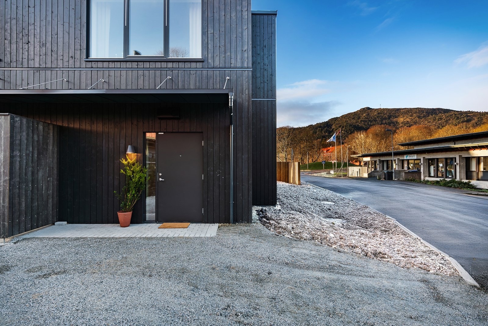 Etter å ha parkert bilen på din egen garasjeplass med elbillader, spaserer du enkelt til boligen. Her blir du møtt av et innbydende inngangsparti og en behagelig atmosfære. Galleribilde