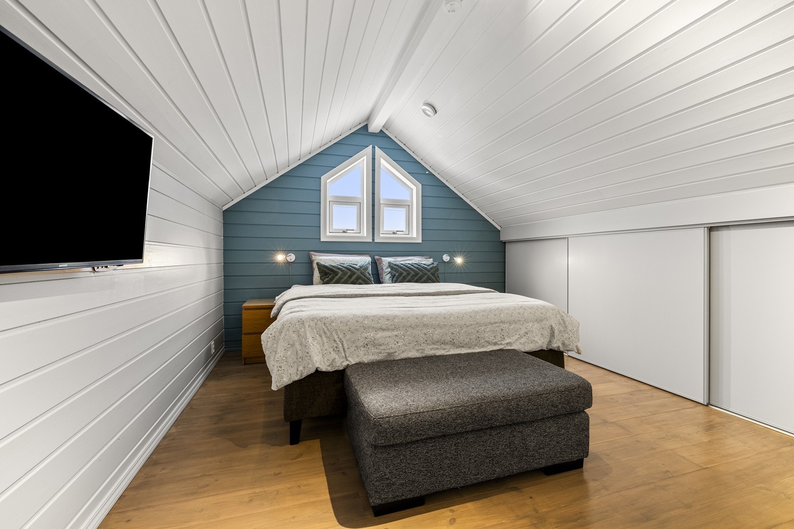 Loftsareal benyttet som soverom. Panelte overflater og skyvedørsgarderobe. Galleribilde