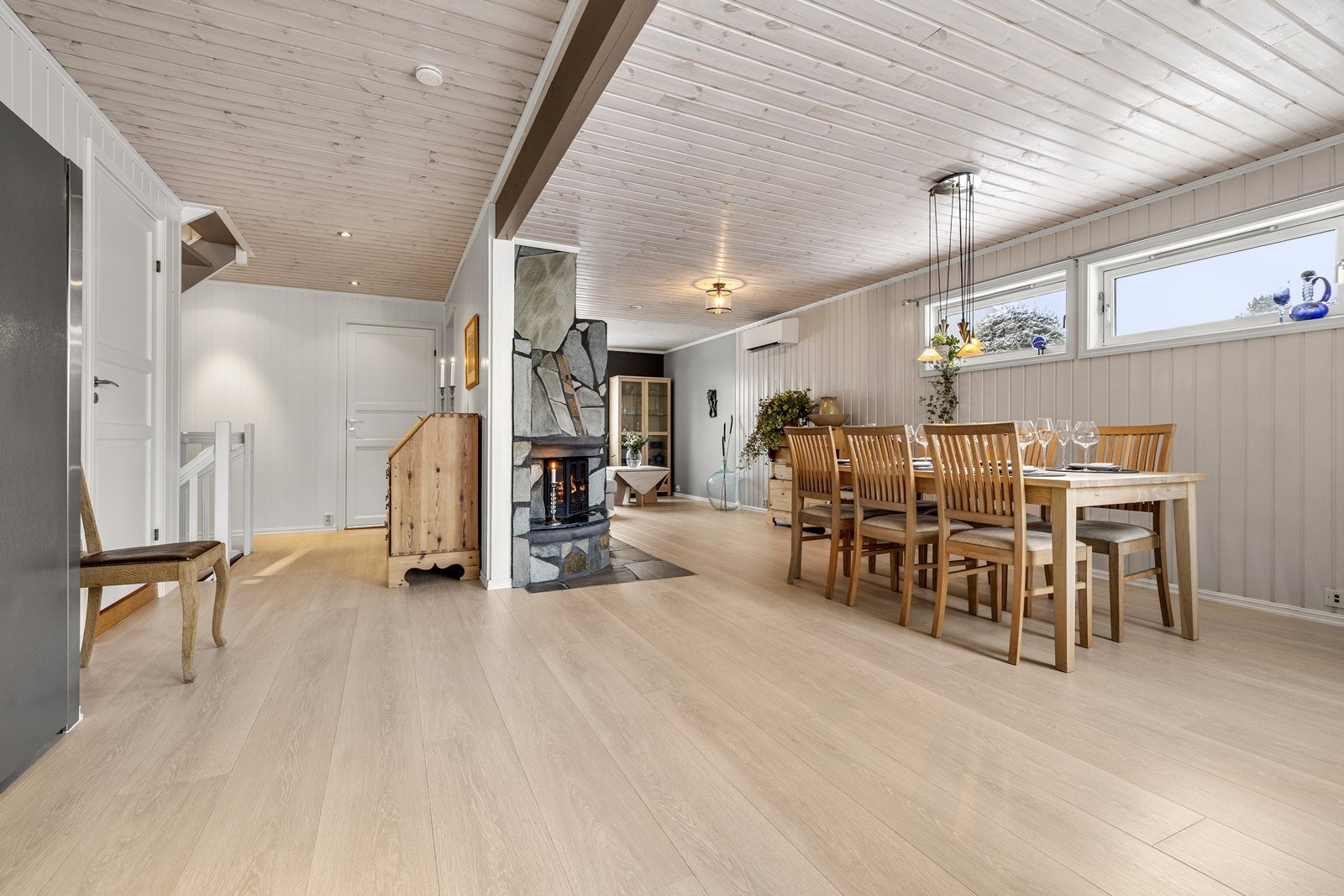 Rommet oppleves innbydende og sosialt, med panelte overflater og lyse fargetoner. Galleribilde