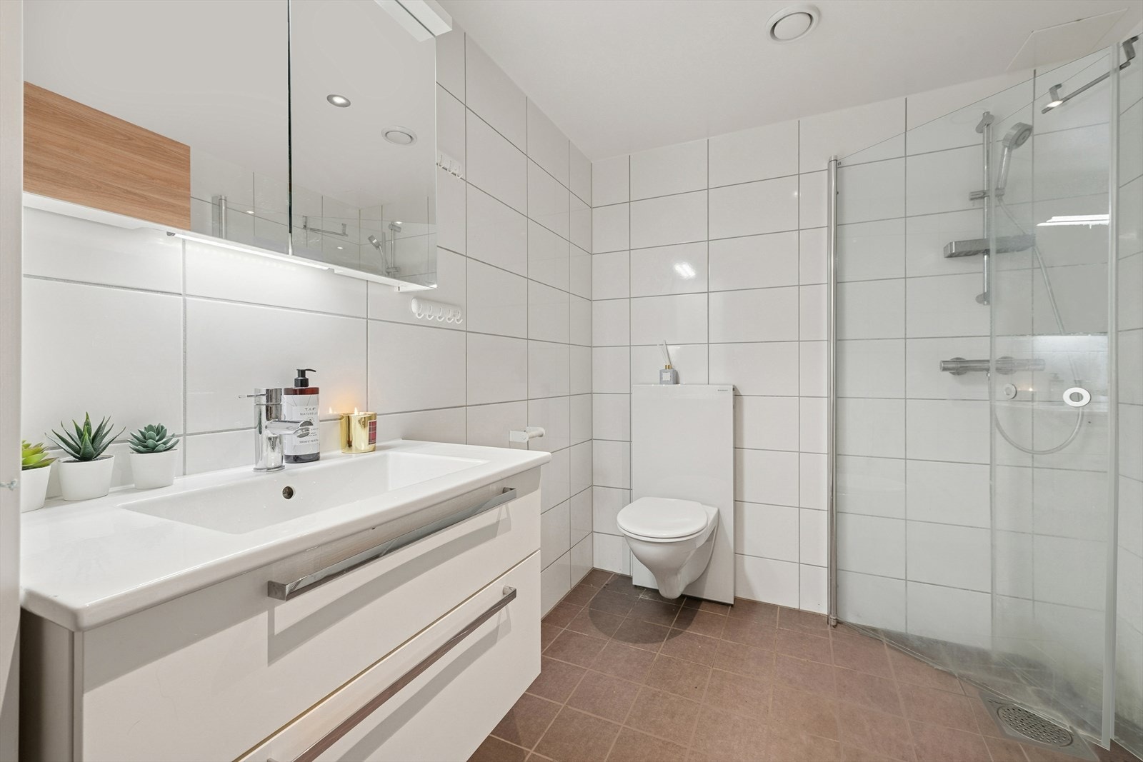 Baderommet har alt man har behov for. Vegghengt toalett, servant med underskap, dusjhjørne og opplegg til vask/tørk. Galleribilde