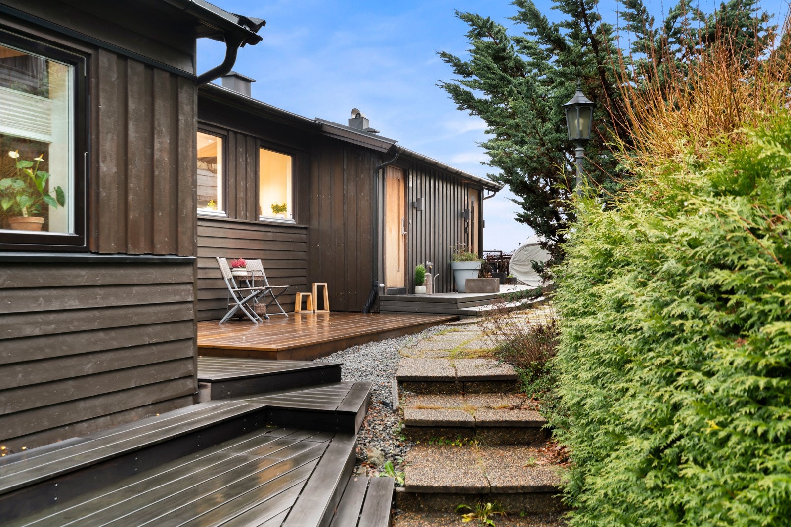 Pent opparbeidet tomt med liten hageflekk og platting ved inngangsparti. Galleribilde