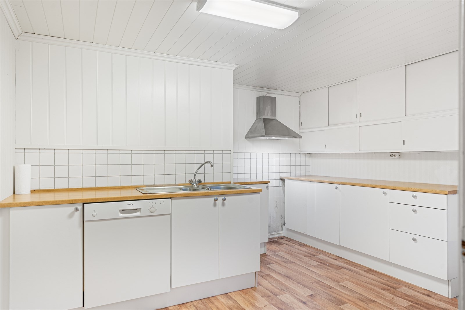 Lyst kjøkken med masse skap- og benkeplass Galleribilde