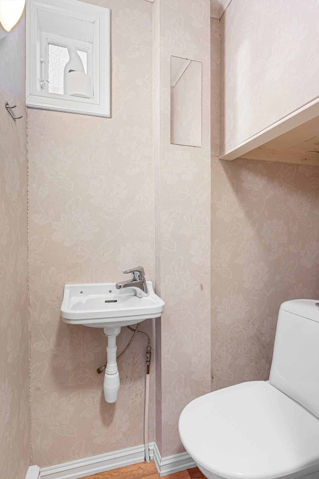 Toalettrom i 1. etasje med tapet på veggoverflater og belegg på gulvet Galleribilde