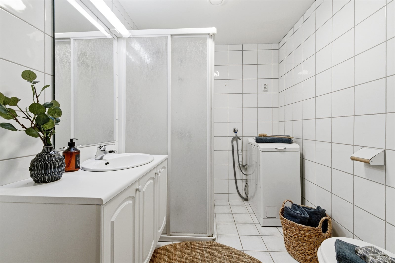 Lyst og romslig flislagt bad og wc Galleribilde