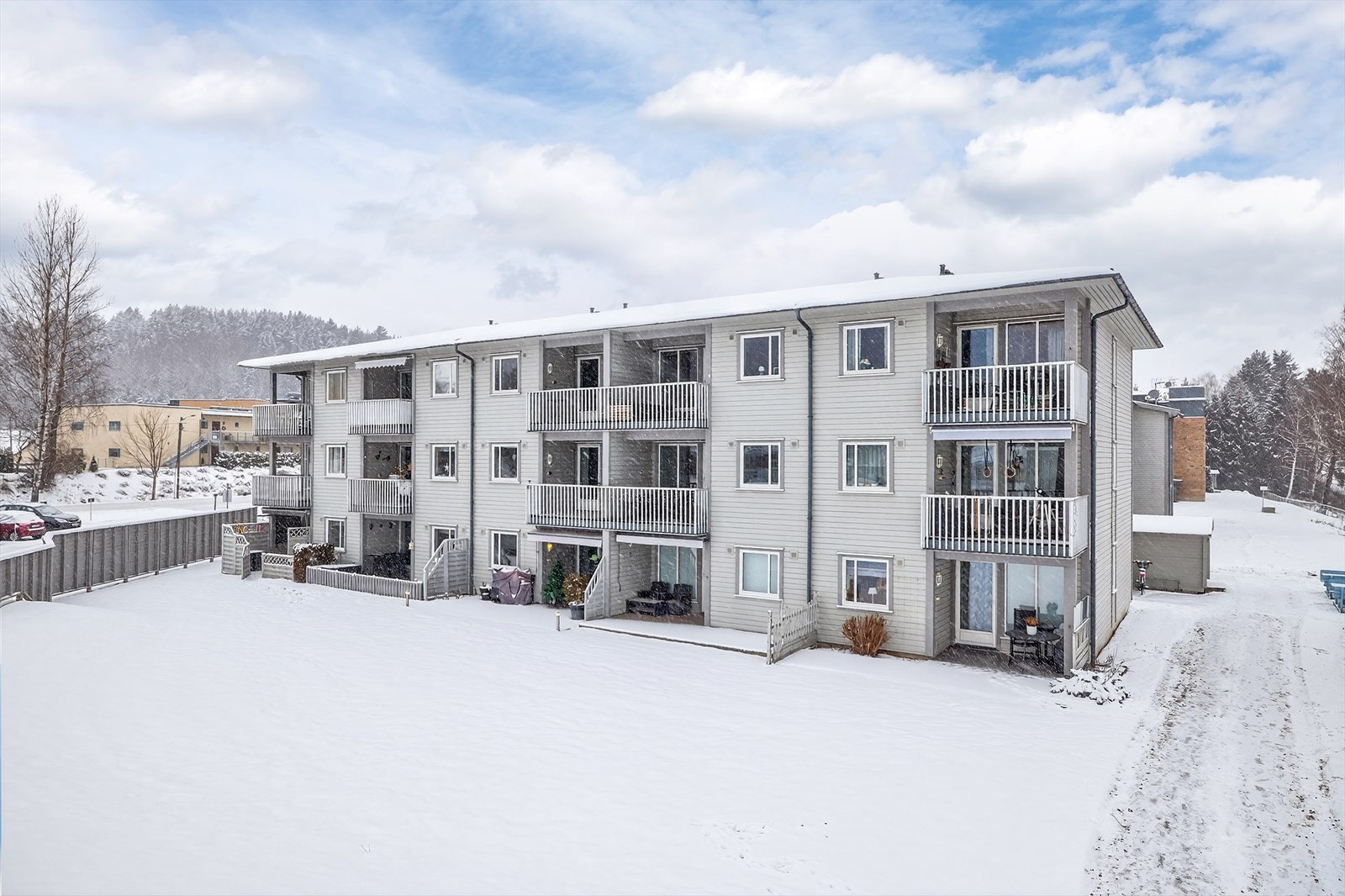 Sentrumsnær beliggenhet med asfaltert parkering med el-bil ladere og store grøntarealer Galleribilde