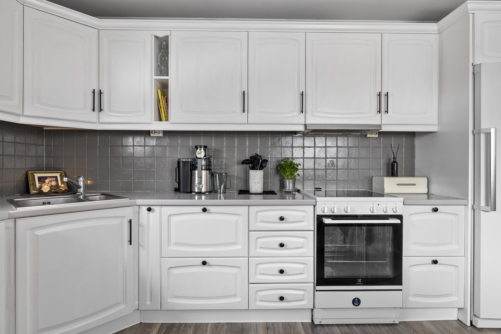 Mellom benkeplaten og overskapene er det pene fliser. Galleribilde