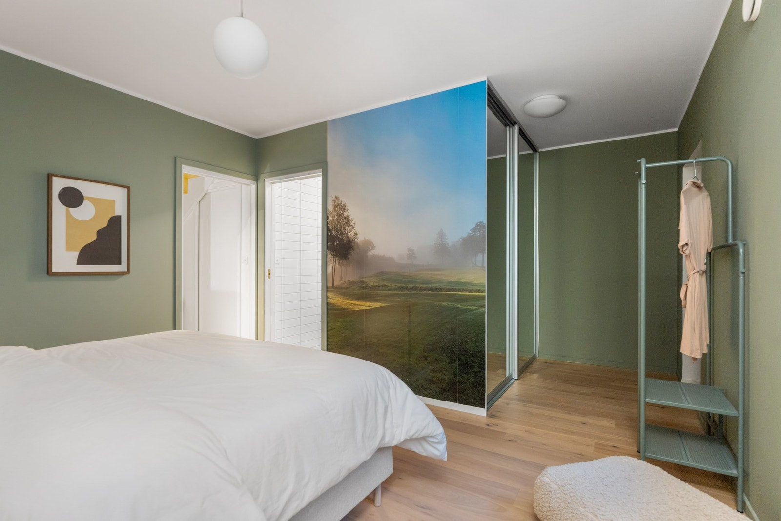 Her er det innebygget skyvedørsgarderobe med speilfronter, samt inngang til etasjens bad. Galleribilde