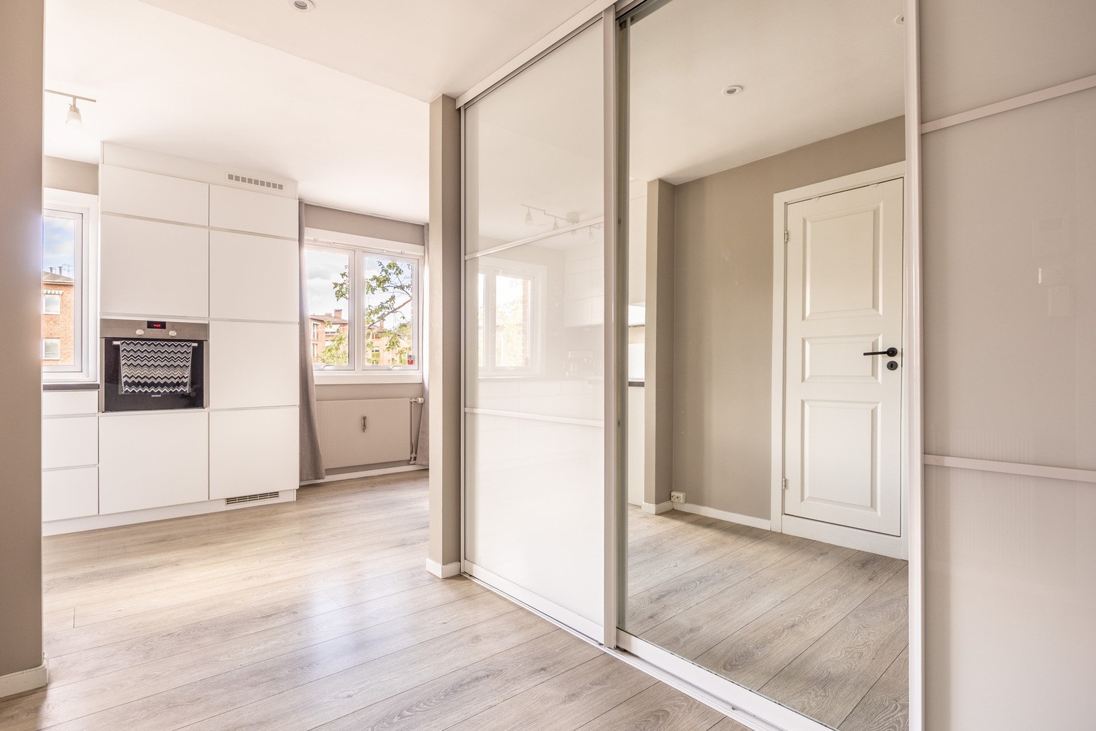 Lys og romslig entré med stor skyvedørs garderobe. Galleribilde